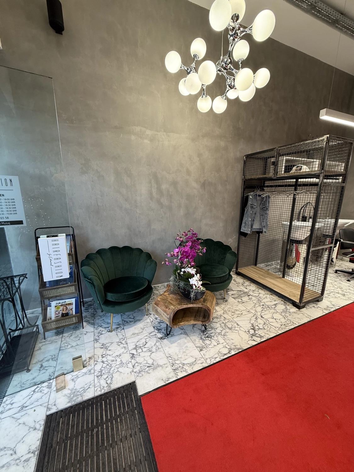 Hairfashion by Edmond - Haarschnitt und Styling - Innenansicht eines Friseursalons mit einer roten Telefonzelle.