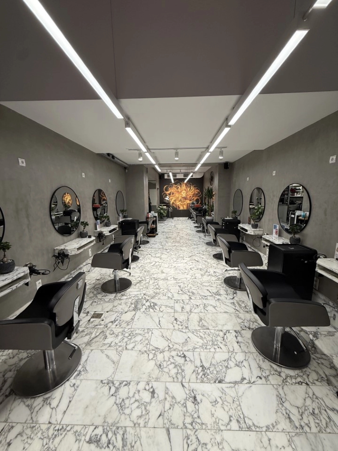 Hairfashion by Edmond - Haarschnitt und Styling - Innenansicht eines Friseursalons mit einer roten Telefonzelle.