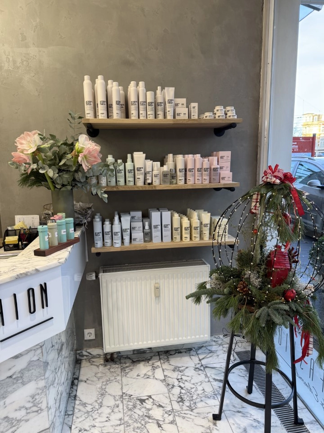 Hairfashion by Edmond - Haarschnitt und Styling - Innenansicht eines Friseursalons mit einer roten Telefonzelle.