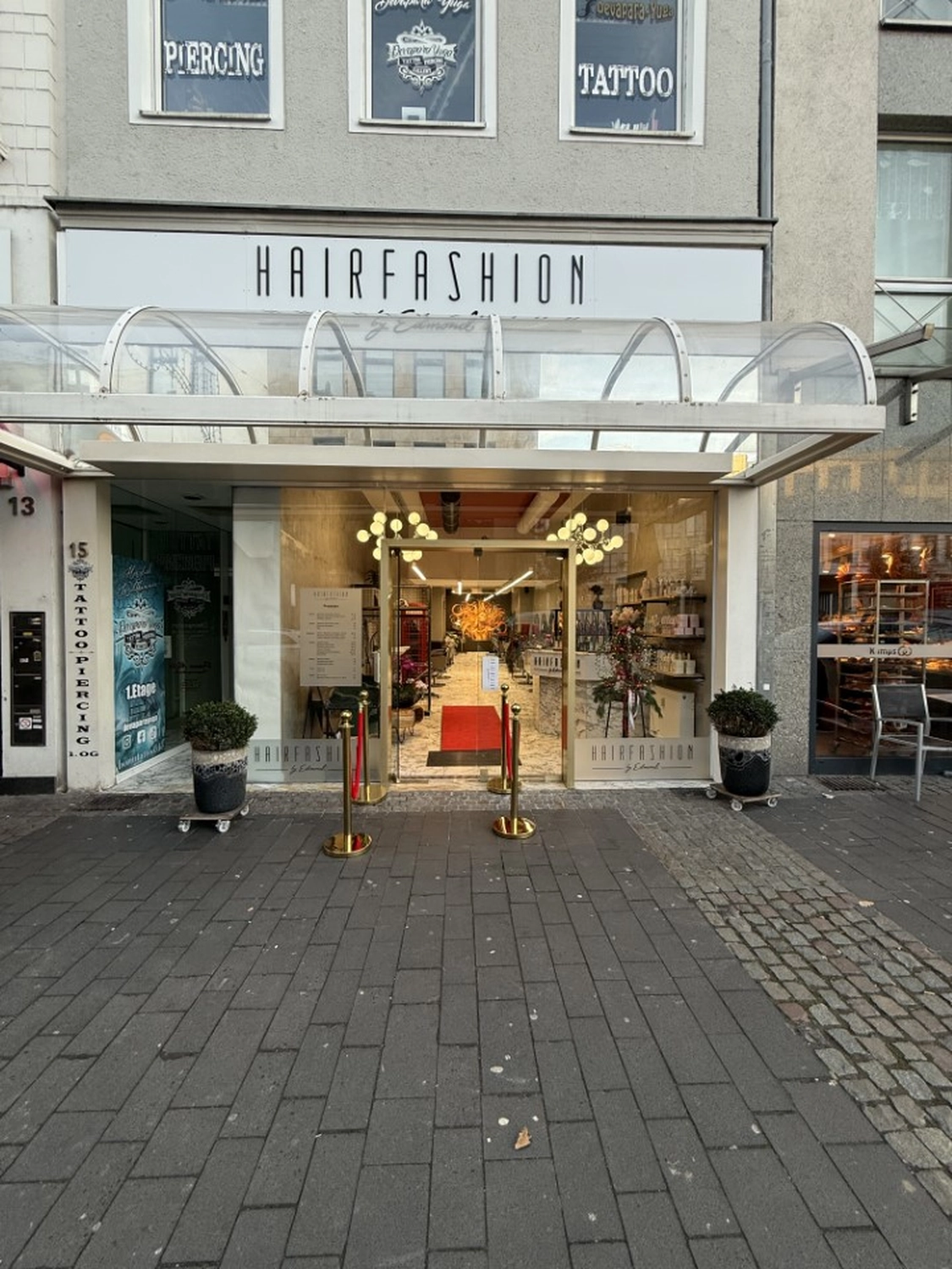 Hairfashion by Edmond - Haarschnitt und Styling - Innenansicht eines Friseursalons mit einer roten Telefonzelle.